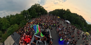Zakes Bantwini holding the South African flag aboard a music float at the Rave The Planet parade in Berlin