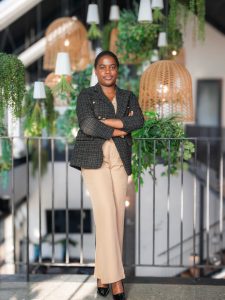Siphosethu Sirayi, founder of HBS Interiors, standing beside a contemporary cabinet against a black feature wall